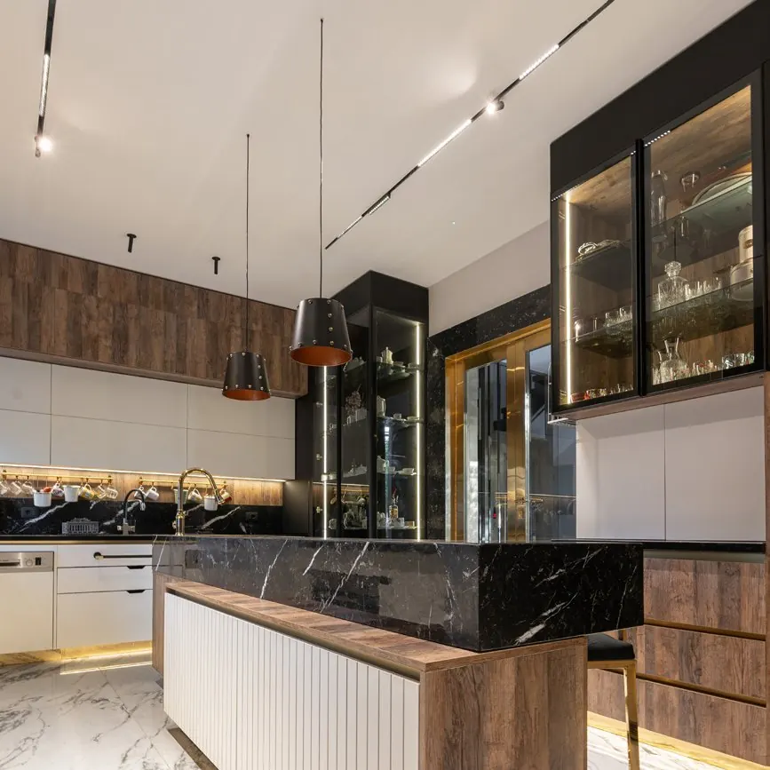 Installed Stova kitchen with a black marble island and lit display cabinets